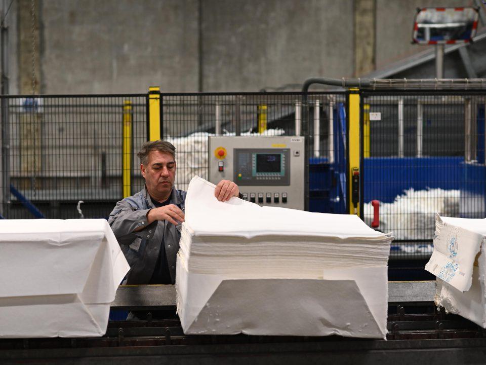 male worker counting pile of towels